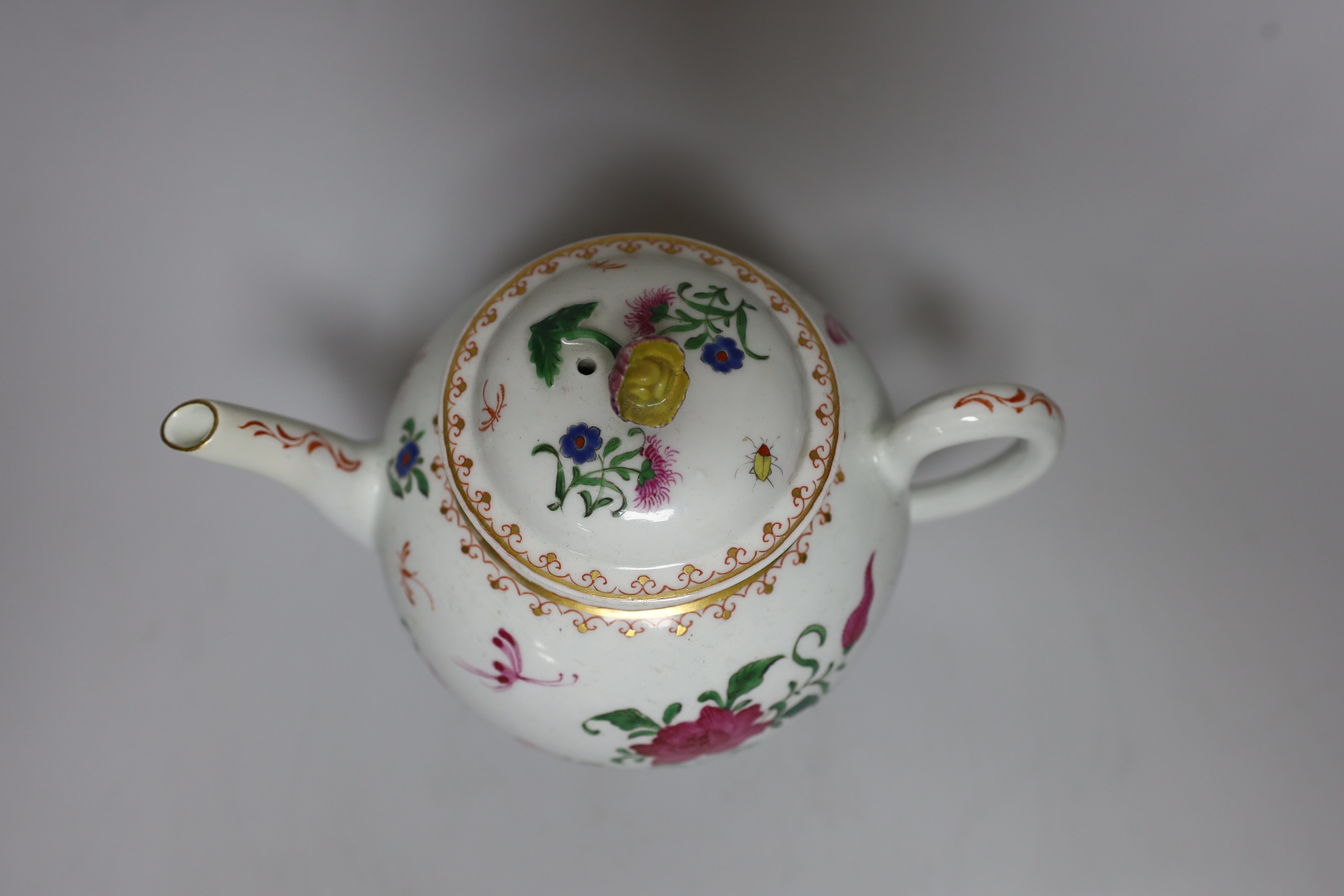A Worcester teapot and cover, painted with Chinese style flowers and winged insects, c.1770, 14cm tall